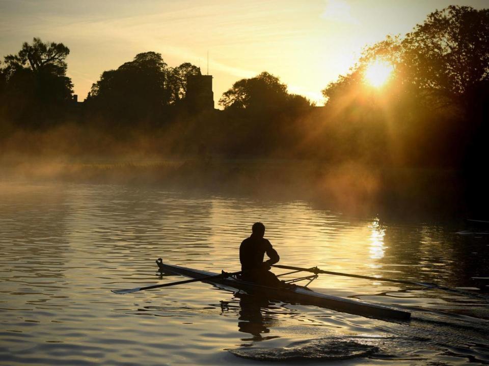 A rower trains on the River Cam in Cambridge at sunrise on Tuesday as early morning mist hangs over the water (PA)