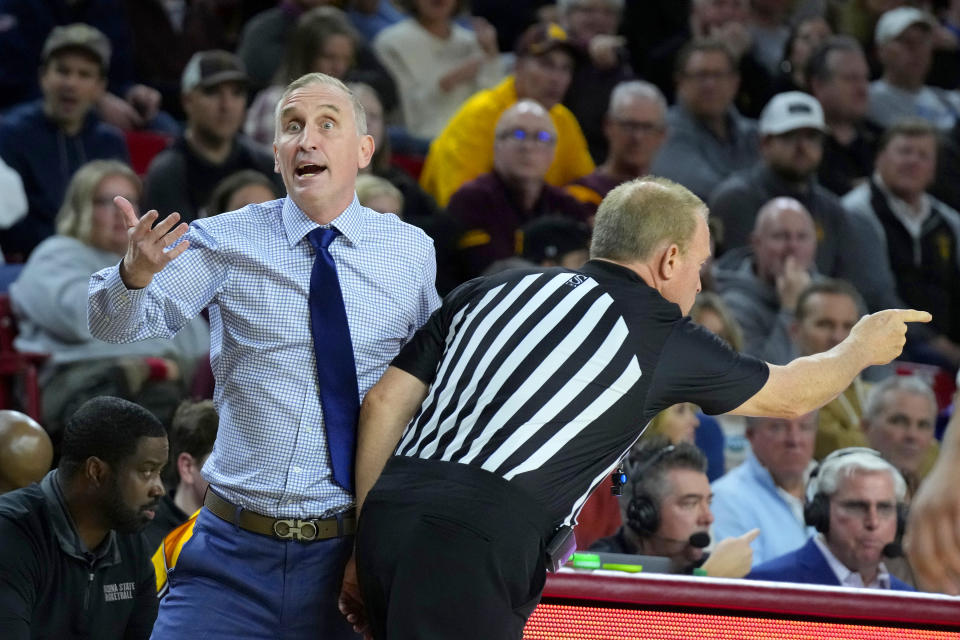 Arizona State head coach Bobby Hurley, left, argues with a referee as he collides with another referee during the first half of an NCAA college basketball game against UCLA Wednesday, Jan. 17, 2024, in Tempe, Ariz. (AP Photo/Ross D. Franklin)