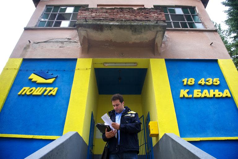 Postman Filip Filipovic checks documents on October 7, 2013 as he leaves the post office in Kursumlijska Banja, some 300 kms south of the capital Belgrade