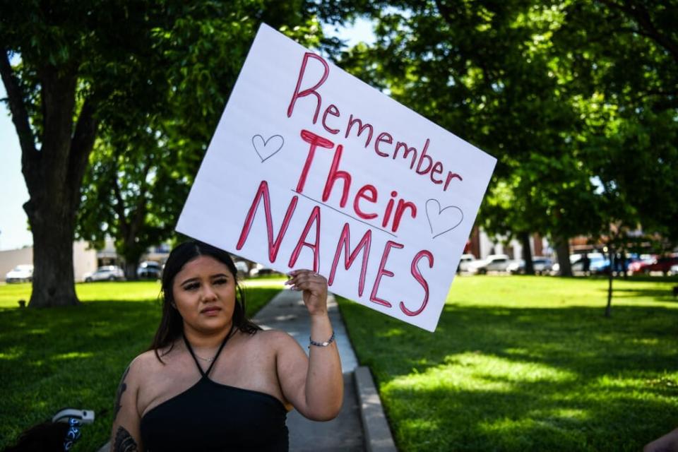 A local resident holds a placard that reads Prayers 4 Uvalde as they grieve for the victims of the mass shooting at Robb Elementary School in Uvalde, Texas, on May 25, 2022. (Photo by CHANDAN KHANNA/AFP via Getty Images)