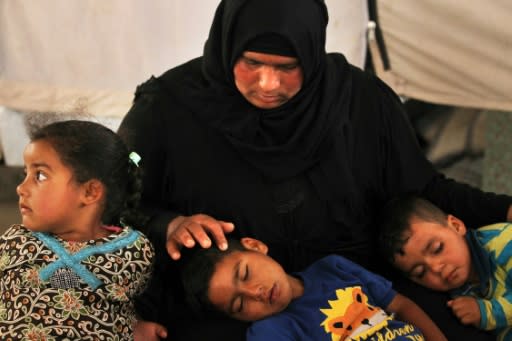 Salima, a 36-year-old mother of four living in the Laylan 2 displacement camp, sits with her children in their tent at the camp, southeast of Kirkuk in northern Iraq