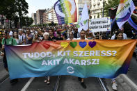 People march holding a banner that reads "Do you know who you love? Whoever you want!" march during a gay pride parade in Budapest, Hungary, Saturday, July 24, 2021. Rising anger over policies of Hungary's right-wing government filled the streets of the country's capital on Saturday as thousands of LGBT activists and supporters marched in the city's Pride parade. (AP Photo/Anna Szilagyi)