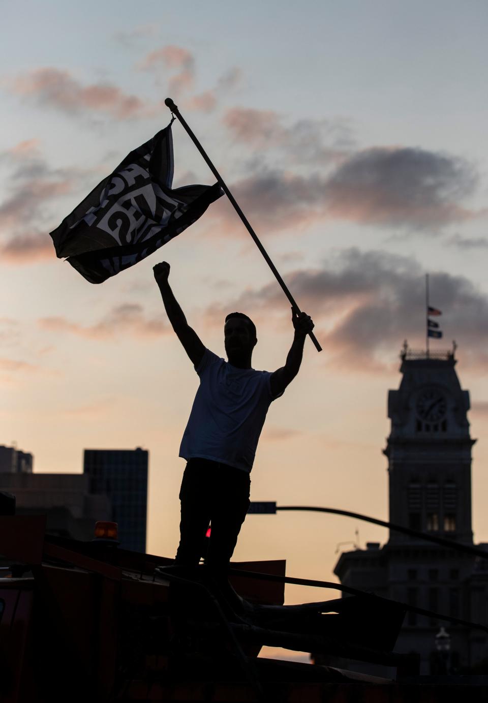 Dylan O'Donoghue stood atop a barricade at Fifth and Jefferson Streets in Louisville, Kentucky and waved a Black Lives Matter flag. Protesters marched through the streets for another night, demonstrating for justice for the late Breonna Taylor. Sept. 26, 2020.