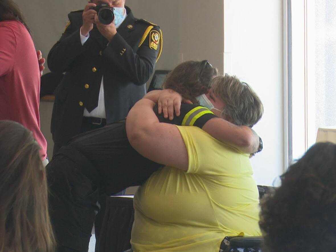 Gisele Marie Bellemore embraces paramedic Luca Distefano, one of four first responders honoured for saving her life, at Essex-Windsor EMS Survivor Day on May 27, 2022. (Mike Evans/CBC - image credit)