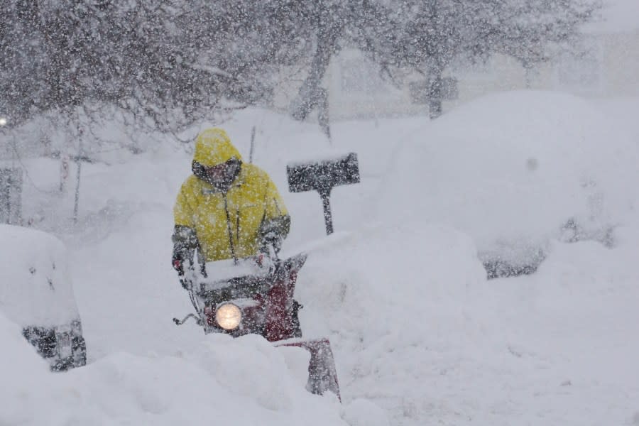 A person uses a blower to clear snow during a storm, Sunday, March 3, 2024, in Truckee, Calif. (AP Photo/Brooke Hess-Homeier)