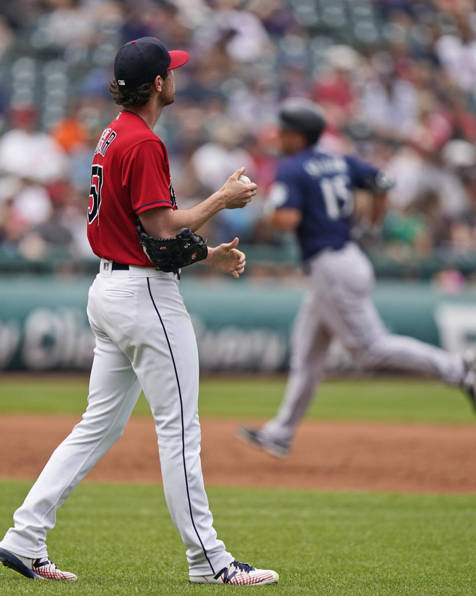 Cleveland Indians starting pitcher Shane Bieber, left, waits for Seattle Mariners' Kyle Seager to run the bases after Seager hit a solo home run in the third inning of a baseball game, Sunday, June 13, 2021, in Cleveland. (AP Photo/Tony Dejak)