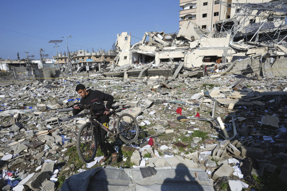 A Palestinian walks through the destruction by the Israeli bombardment in the Nusseirat refugee camp in Gaza Strip, Tuesday, Jan. 16, 2024. (AP Photo/Adel Hana)