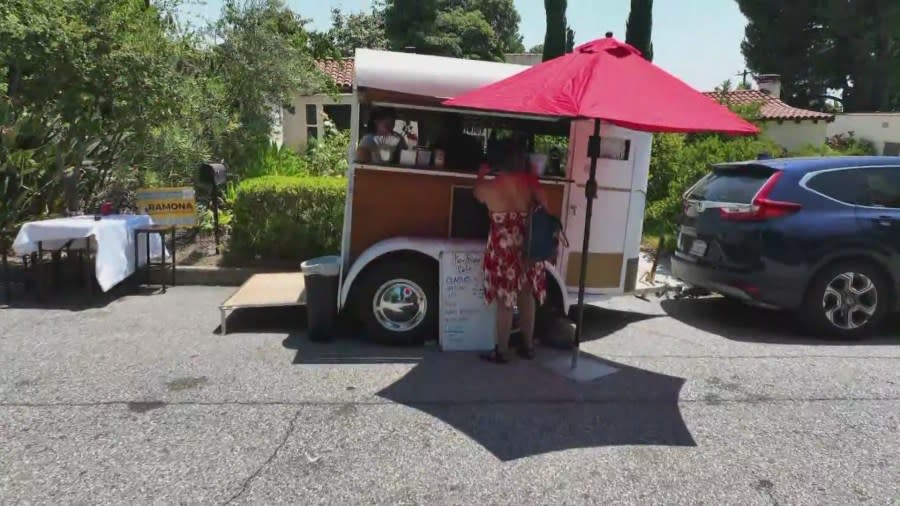 Customers ordering coffee from Ka-Ibigan Cafe, a coffee cart set up in an Altadena neighborhood on July 9, 2024. (KTLA)