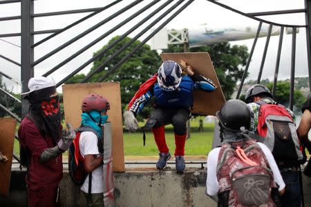 Demonstrators get in the perimeters of an Air Force base while clashing with riot security forces during a rally against Venezuela's President Nicolas Maduro's Government in Caracas, Venezuela, June 24, 2017. REUTERS/Marco Bello