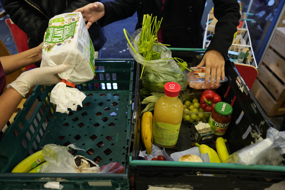 Volunteers pack boxes with food for customers at the community food pantry in Vauxhall, London, Wednesday, Nov. 16, 2022. Just three weeks after taking office, British Prime Minister Rishi Sunak faces the challenge of balancing the nation's finances while helping millions of people slammed by a cost-of-living crisis as Russia's war in Ukraine pushes up energy prices and slows economic growth. Treasury chief Jeremy Hunt will deliver the government’s plan for tackling a sputtering economy in a speech to the House of Commons on Thursday. (AP Photo/Frank Augstein)