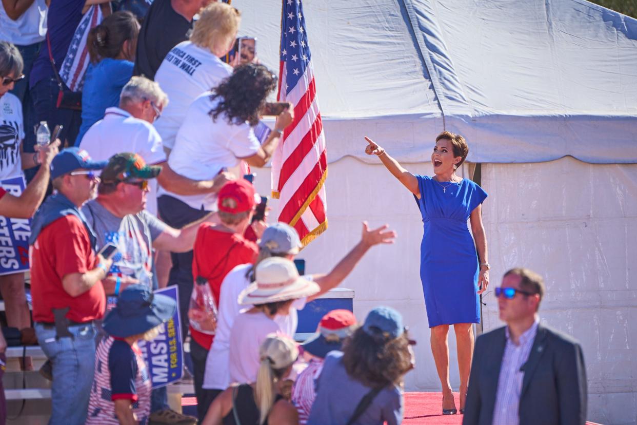 Gubernatorial candidate Kari Lake points to fans as she takes the stage during former President Donald Trump's rally at Legacy Sports Park in Mesa on Sunday, Oct. 9, 2022.