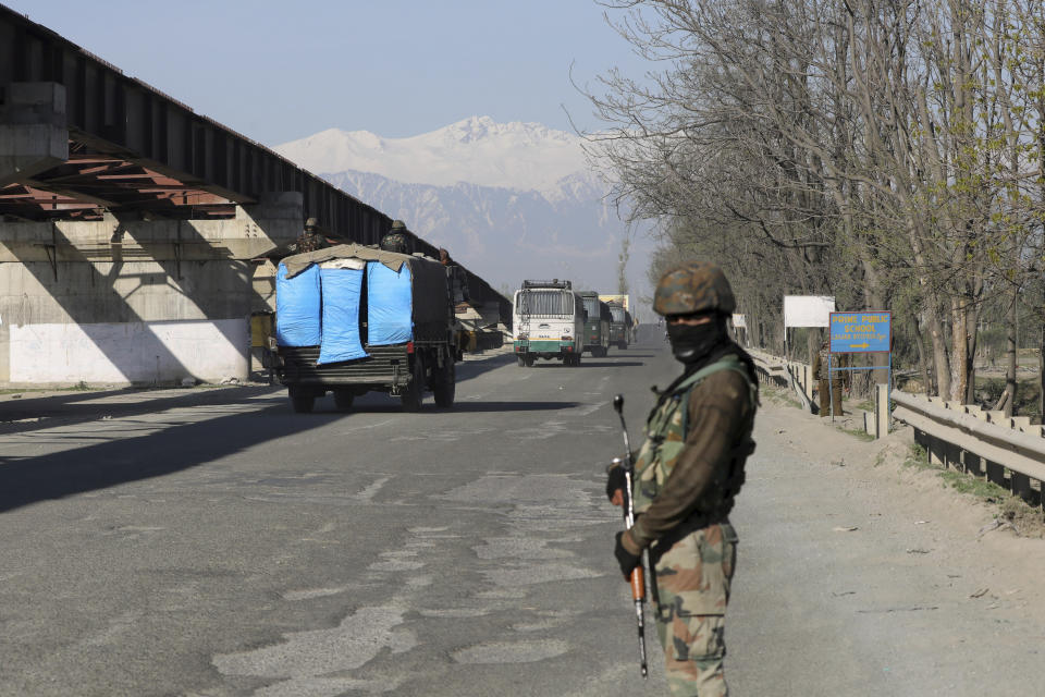 An Indian army soldier stands guard as an army convoy moves on a highway on the outskirts of Srinagar, Indian controlled Kashmir, Sunday, Feb. 7, 2019. Authorities in Indian portion of Kashmir have banned civilian traffic on Srinagar-Jammu national highway for two days in a week for the safe passage of Indian security force convoys. The move comes after the February 14 suicide bombing on a paramilitary convoy which killed more than 40 paramilitary personnel. (AP Photo/Dar Yasin)