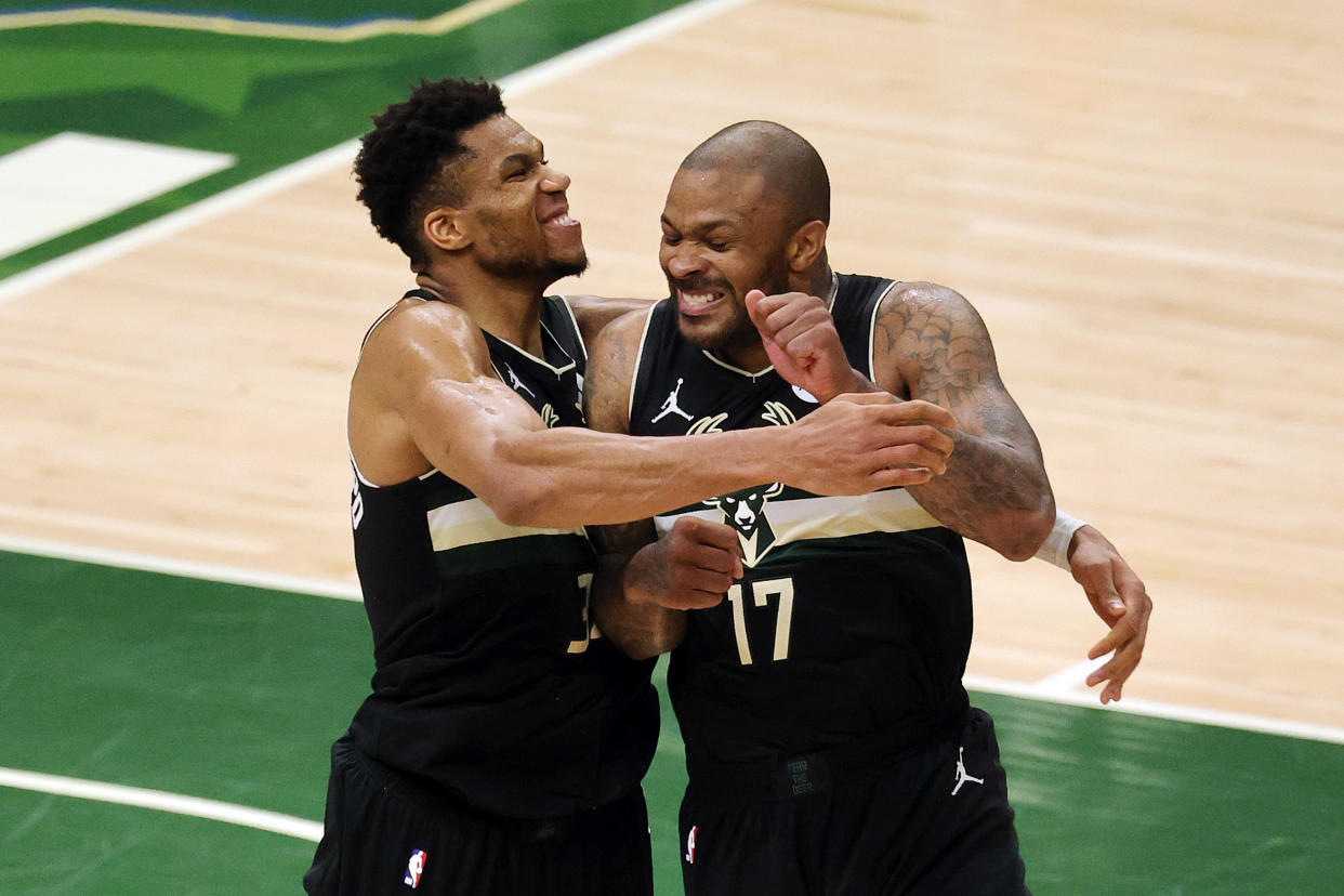 Giannis Antetokounmpo celebrates with P.J. Tucker in the final seconds of the Bucks' NBA Finals-clinching win over the Phoenix Suns on Tuesday. (Jonathan Daniel/Getty Images)