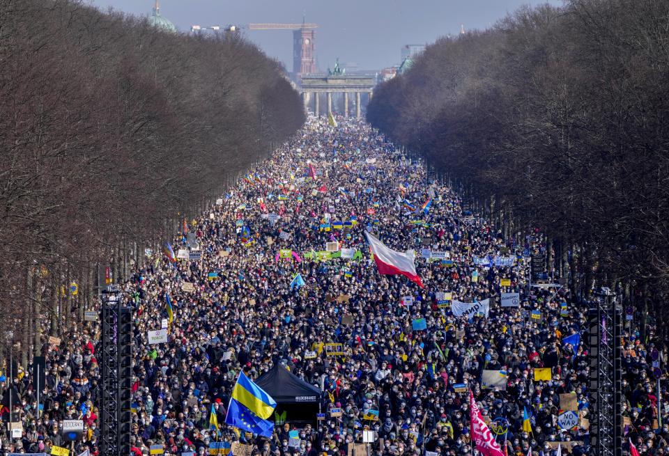 FILE - People walk down the bulevard 'Strasse des 17. Juni' ahead of a rally against Russia's invasion of Ukraine in Berlin, Germany, on Feb. 27, 2022. By ending 77 years of almost uninterrupted peace in Europe, war in Ukraine war has joined the dawn of the nuclear age and the birth of manned spaceflight as a watershed in history. After nearly a half-year of fighting, tens of thousands of dead and wounded on both sides, massive disruptions to supplies of energy, food and financial stability, the world is no longer as it was. (AP Photo/Markus Schreiber)