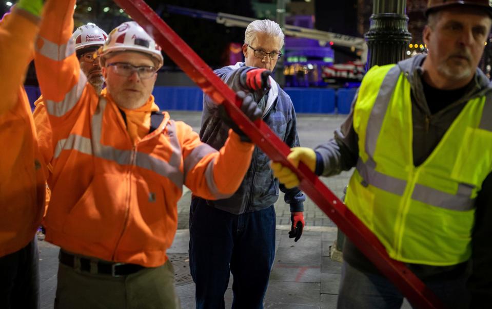 Kevin Andrews, 62, of Macomb Township, a maintenance supervisor for The Salvation Army Great Lakes Division, gives direction during the assembly of a giant red kettle early morning at Cadillac Square in Detroit on Friday, Nov. 10, 2023.