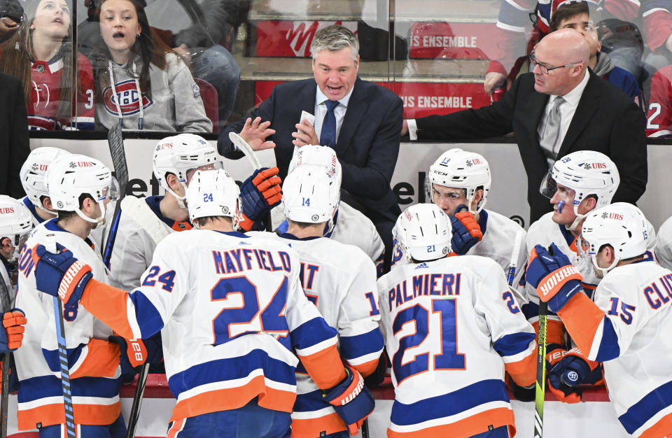 New York Islanders coach Patrick Roy, center, talks to players during the first period of the team's NHL hockey game against the Montreal Canadiens on Thursday, Jan. 25, 2024, in Montreal. (Graham Hughes/The Canadian Press via AP)