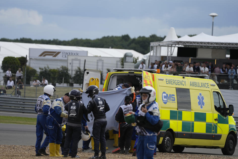 Alfa Romeo driver Guanyu Zhou of China, centre, receives medical treatment after he was involved in a crash at the start of the British Formula One Grand Prix at the Silverstone circuit, in Silverstone, England, Sunday, July 3, 2022. (AP Photo/Frank Augstein)