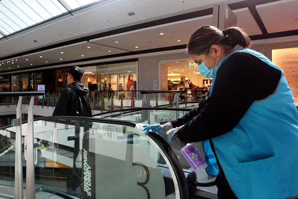 A member of the presentation and hygiene team cleans handrails at Broadway Shopping Centre in Sydney, Australia. 