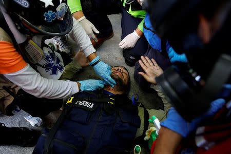 A media member receives help at a rally during a strike called to protest against Venezuelan President Nicolas Maduro's government in Caracas. REUTERS/Carlos Garcia Rawlins