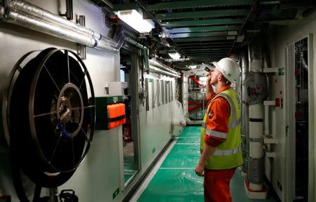 A man makes final checks to the British Aircraft carrier HMS Queen Elizabeth, as preparations are made for its maiden voyage, in its dock at Rosyth, in Scotland, Britain June 21, 2017. Photograph taken June 21, 2017. REUTERS/Russell Cheyne