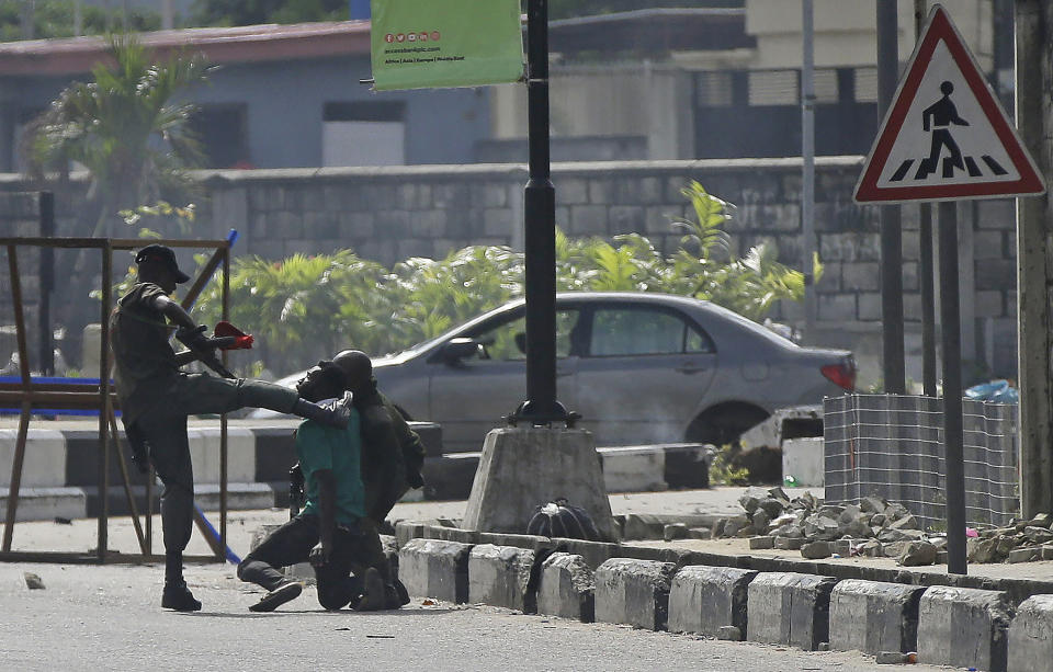 FILE - In this Oct. 21, 2020, file photo, a police officer detains a protester near Lekki toll gate in Lagos, Nigeria. The protests started in Lagos against a police unit known as the Special Anti-Robbery Squad, or SARS, which faced widespread accusations of brutality, unwarranted arrests and bribery. It climaxed on Oct. 20, 2020, when protesters were killed nationwide, according to Amnesty International's Nigerian office. (AP Photo/Sunday Alamba, File)