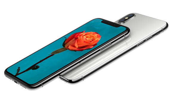 Two iPhone X devices. One is facedown, the other is displaying a picture of a rose.