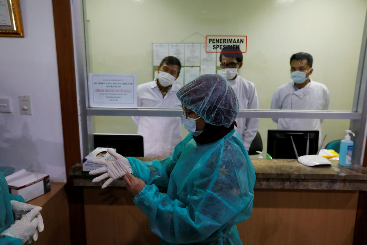 Journalists wear protective suits during a media visit to Indonesian Health Ministry's Laboratorium for Research on Infectious-Diseases, following the outbreak of the new coronavirus in China, in Jakarta, Indonesia, February 11, 2020. REUTERS/Willy Kurniawan