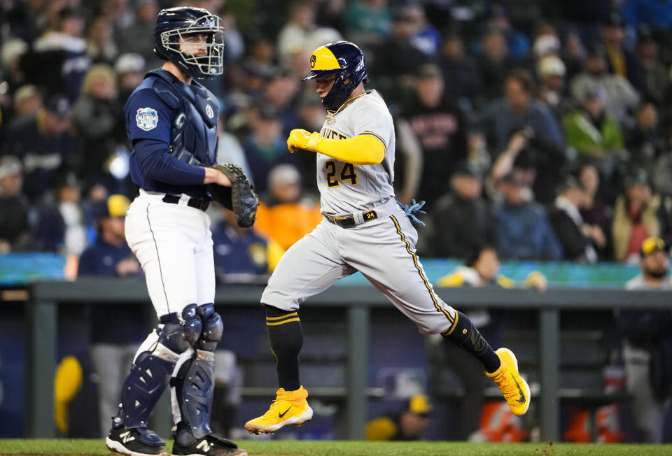 Milwaukee Brewers' William Contreras scores on a single by Luke Voit, while Seattle Mariners catcher Tom Murphy looks to the infield during the seventh inning of a baseball game Wednesday, April 19, 2023, in Seattle. (AP Photo/Lindsey Wasson)