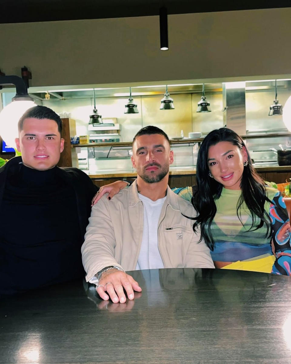 A picture of Al Perkins, Brent, and Ella, sitting at a table in a restaurant.