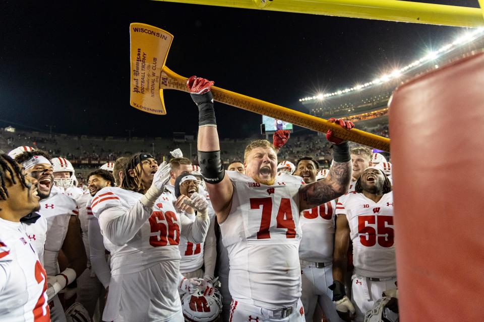 Wisconsin offensive lineman Michael Furtney (74) celebrates with the Axe after a 28-14 win over Minnesota on Nov. 25, 2023.