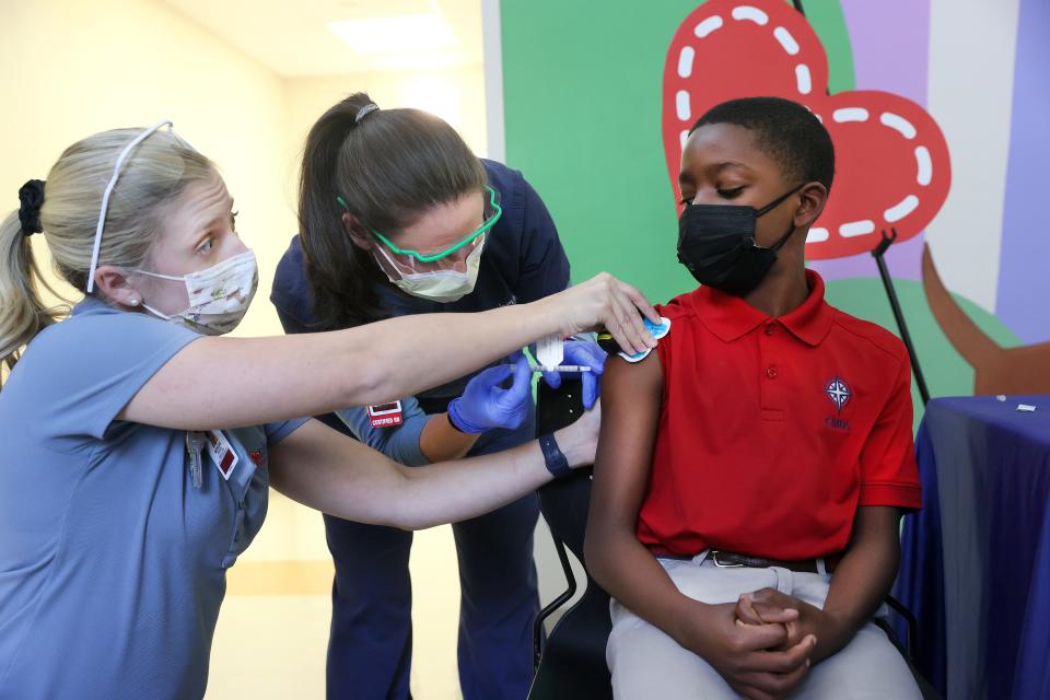 Certified Child Life Specialist Morgan Morgan chats with Arthur Wharton, 11, as Shana Rodgers administers his Pfizer COVID-19 vaccine which has been approved for 5-11 year olds, at Le Bonheur Children's Hospital on Thursday, Nov. 4, 2021.