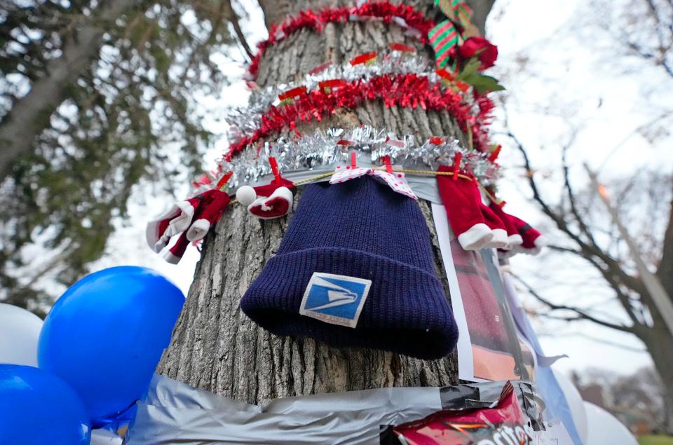 A postal worker hat is attached to the tree at a makeshift memorial on Tuesday, Dec. 13, where Aundre Cross, a 44-year-old U.S. Postal Service employee was shot and killed while delivering mail Dec. 9 in the 5000 block of North 65th Street in Milwaukee.