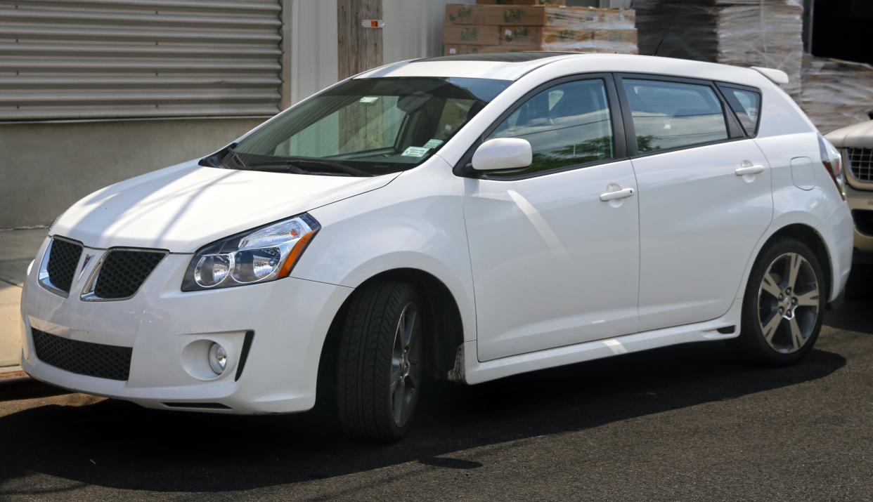 White Pontiac Vibe 2010 parked on a street.