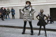 A woman poses with the "Fearless Girl" statue after it is unveiled at its new location in front of the New York Stock Exchange, Monday, Dec. 10, 2018, in New York. The statue, considered by many to symbolize female empowerment, was previously located near the Charging Bull statue on lower Broadway. (AP Photo/Mark Lennihan)