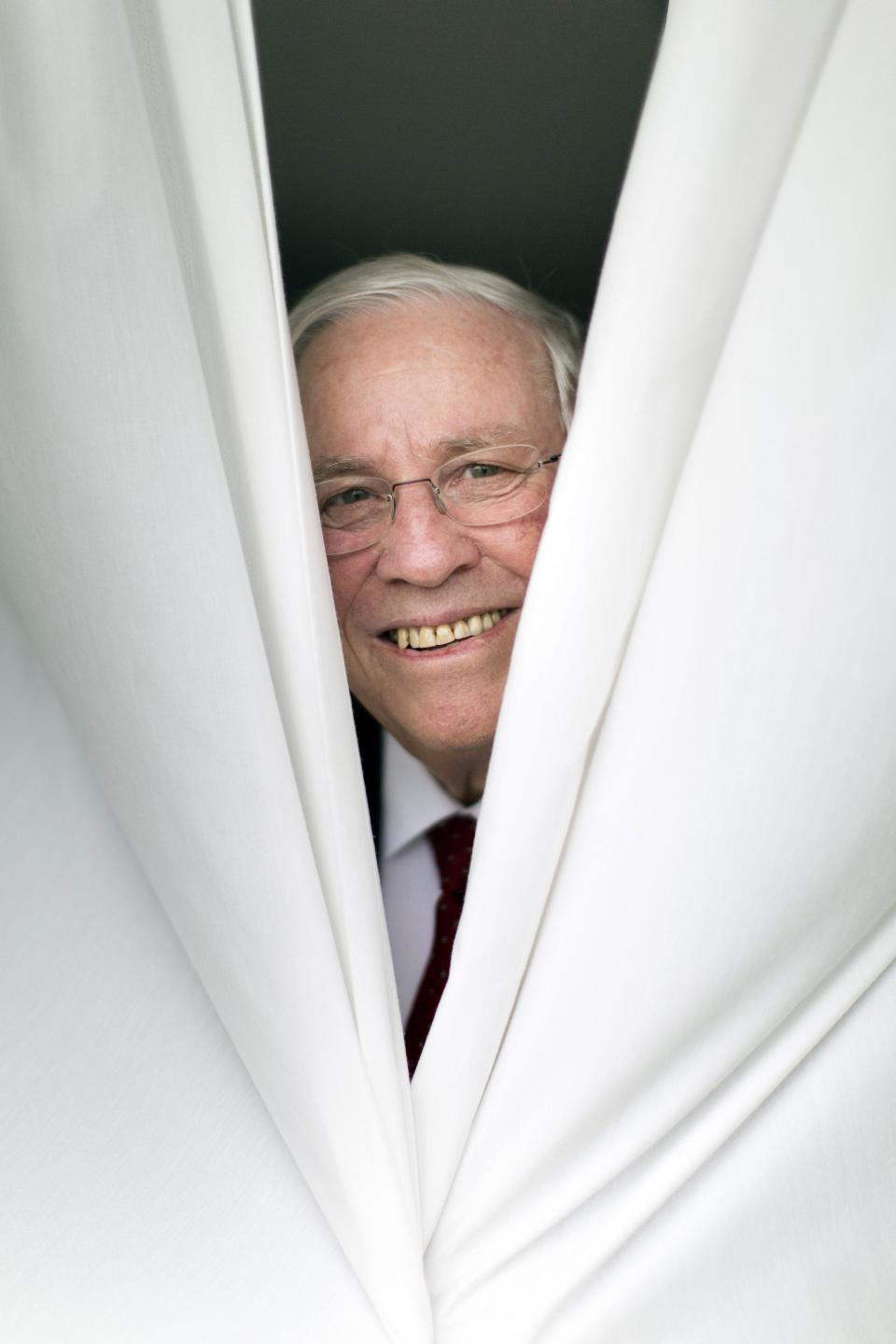 Swiss Lawmaker Christoph Blocher poses behind a curtain for a video journalist of Keystone at his office in Maennerdorf, Switzerland, Friday, May 9, 2014. The Swiss billionaire lawmaker behind the nation’s recent anti-immigration vote is leaving parliament to concentrate on ensuring that Switzerland never joins the European Union. (AP Photo/Keystone, Gaetan Bally)