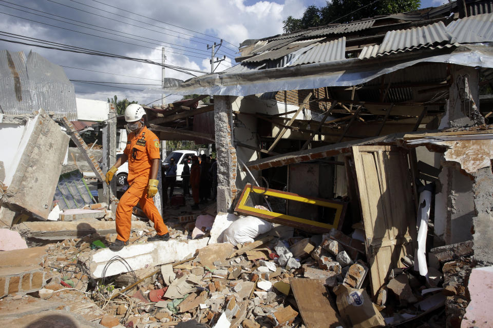 Emergency rescue team members continue to search for victims in the quake-damaged village in Tanjung, Lombok, Indonesia, Tuesday, Aug. 7, 2018. Thousands are left homeless by a powerful quake that ruptured roads and flattened buildings on the Indonesia tourist island Lombok as authorities said rescuers hadn't yet reached all devastated areas and expect the death toll to climb. (AP Photo/Firdia Lisnawati)