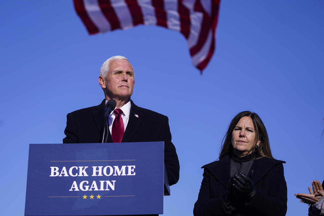 FILE - In this Jan. 20, 2021, file phot, former Vice President Mike Pence speaks after arriving back in his hometown of Columbus, Ind., as his wife Karen watches. Pence is steadily re-entering public life as he eyes a potential run for the White House in 2024. He's writing op-eds, delivering speeches, preparing trips to early voting states and launching an advocacy group likely to focus on promoting the accomplishments of the Trump administration. (AP Photo/Michael Conroy, File)