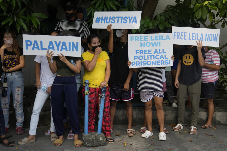 Supporters of detained former opposition Sen. Leila de Lima holds slogans as they wait for her to pass by in Muntinlupa, Philippines, Monday, Oct. 10, 2022. Human rights activists pressed their call Monday for the immediate release of de Lima after she was taken hostage in a rampage by three Muslim militants in a failed attempt to escape from a maximum-security jail. (AP Photo/Aaron Favila)