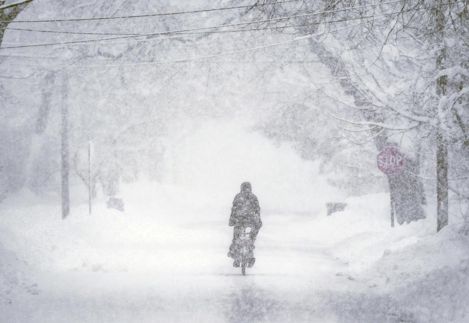 A bicyclist peddles down Noyes Street in the South End of Concord, New Hampshire, during a heavy burst of snow on Monday morning, Jan. 23, 2023.