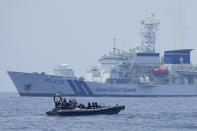 A Philippine Coast Guard rigid hull inflatable boat passes by the Japanese Coast Guard Akitsushima (PLH-32) during a trilateral Coast Guard drill off the waters in Bataan province, Philippines, Tuesday, June 6, 2023. U.S., Japan and Philippine coast guard ships staged law enforcement drills in waters near the disputed South China Sea on Tuesday as Washington pressed efforts to reinforce alliances in Asia amid an increasingly tense rivalry with China.(AP Photo/Aaron Favila)