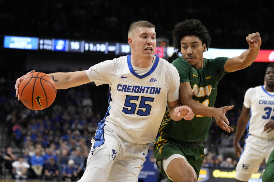 Creighton guard Baylor Scheierman (55) drives to the basket past North Dakota State guard Lance Waddles during the first half of an NCAA college basketball game, Saturday, Nov. 11, 2023, in Omaha, Neb. (AP Photo/Charlie Neibergall)