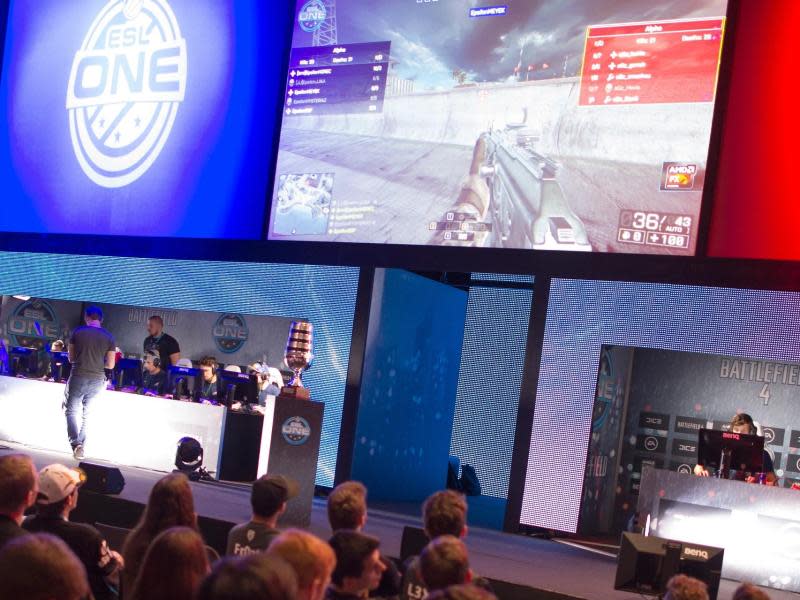 Zuschauer verfolgen auf der Computerspielemesse Gamescom in Köln ein Turnier der eSport-Liga ESL, bei dem zwei Teams "Battlefield 4" gegeneinander spielen. Foto: Marius Becker