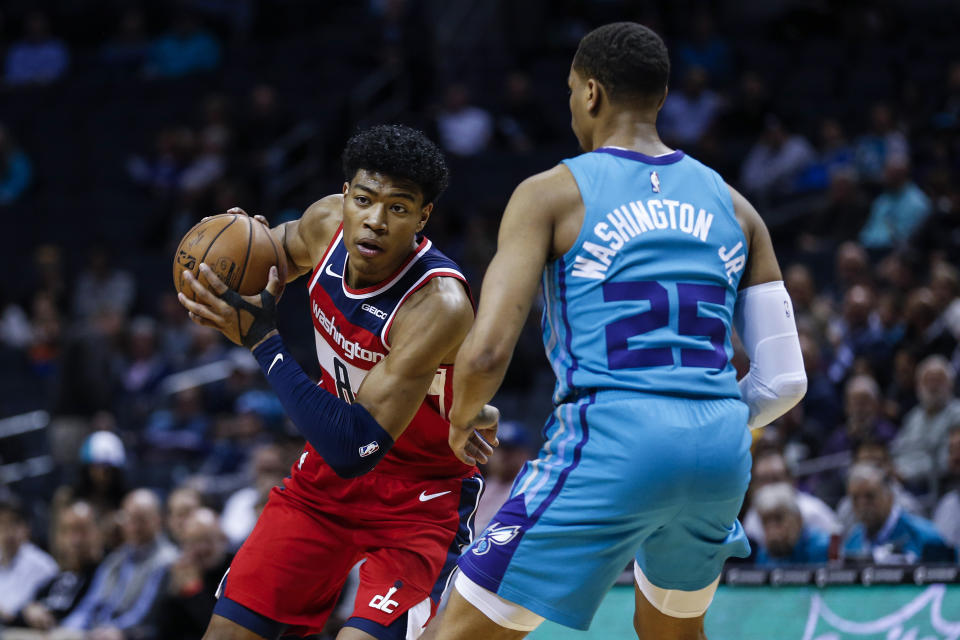 Washington Wizards forward Rui Hachimura, left, looks to drive against Charlotte Hornets forward P.J. Washington in the first half of an NBA basketball game in Charlotte, N.C., Tuesday, Dec. 10, 2019. (AP Photo/Nell Redmond)