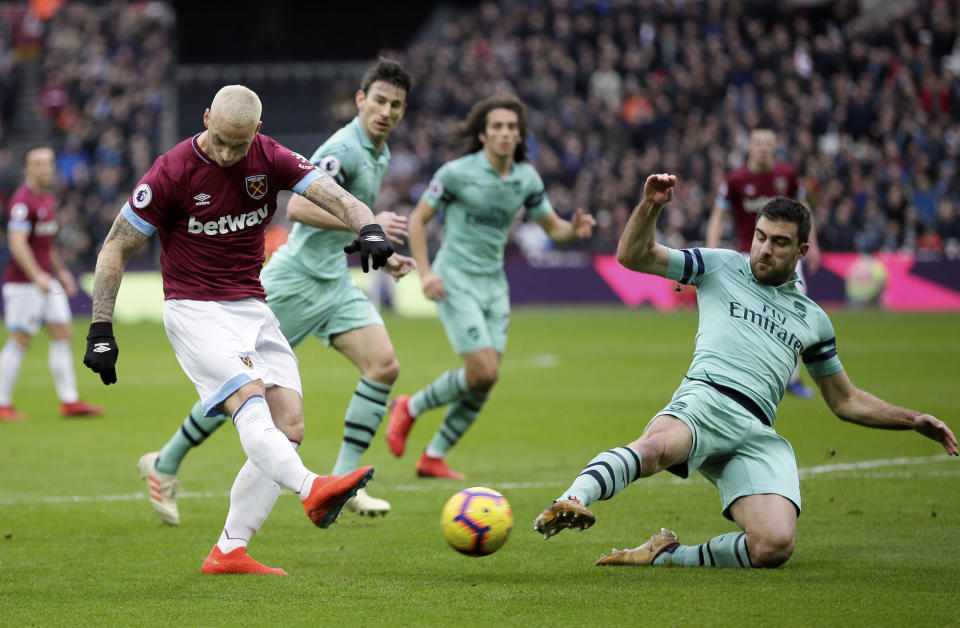 Arsenal's Sokratis Papastathopoulos, right, blocks a shot from West Ham's Marko Arnautovic during the English Premier League soccer match between West Ham United and Arsenal at London Stadium in London, Saturday, Jan. 12, 2019. (AP Photo/Tim Ireland)