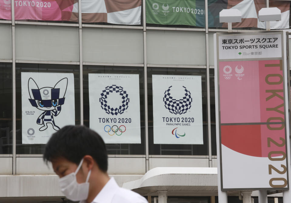 A man wearing a face mask to protect against the spread of the coronavirus walks by posters to promote the Tokyo Olympic Games in Tokyo Monday, June 7, 2021. (AP Photo/Koji Sasahara)
