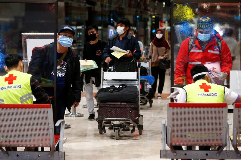 Passengers stand in line to have temperature and oxygen level checked before boarding flights at Soekarno Hatta Airport amid the coronavirus disease (COVID-19) outbreak in Jakarta