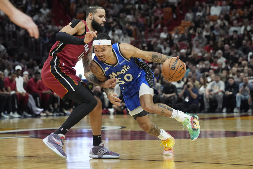 Miami Heat forward Caleb Martin (16) defends Orlando Magic guard Cole Anthony (50) during the first half of an NBA basketball game, Friday, Jan. 12, 2024, in Miami. (AP Photo/Marta Lavandier)