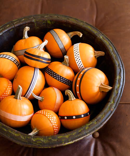 <p>For a no-fuss fall centerpiece, heap mini pumpkins in a shallow bowl. Attach double-stick tape to lengths of black, orange, and white patterned ribbon, then wrap around each squash.</p><p><a class="link " href="https://www.amazon.com/dp/B07GN36SDQ/?tag=syn-yahoo-20&ascsubtag=%5Bartid%7C10055.g.1714%5Bsrc%7Cyahoo-us" rel="nofollow noopener" target="_blank" data-ylk="slk:SHOP RIBBON;elm:context_link;itc:0;sec:content-canvas">SHOP RIBBON</a><br></p>