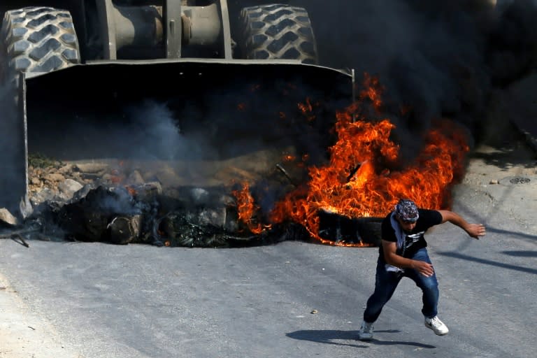 A Palestinian protester runs from the path of an Israeli army bulldozer during clashes in the village of Kobar, west of Ramallah, on July 22, 2017