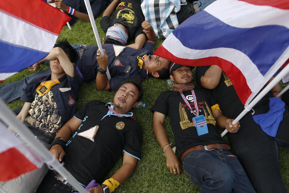 Anti-government protesters rest after breaking into the compound of the Royal Thai Army headquarters in Bangkok